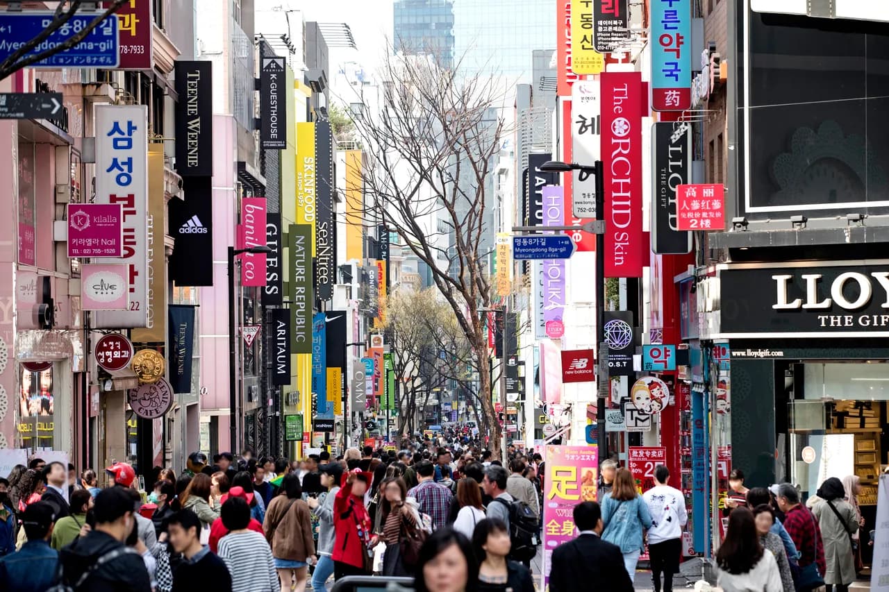 The crowded main shopping street of Myeongdong, Seoul, lined with stores and signs